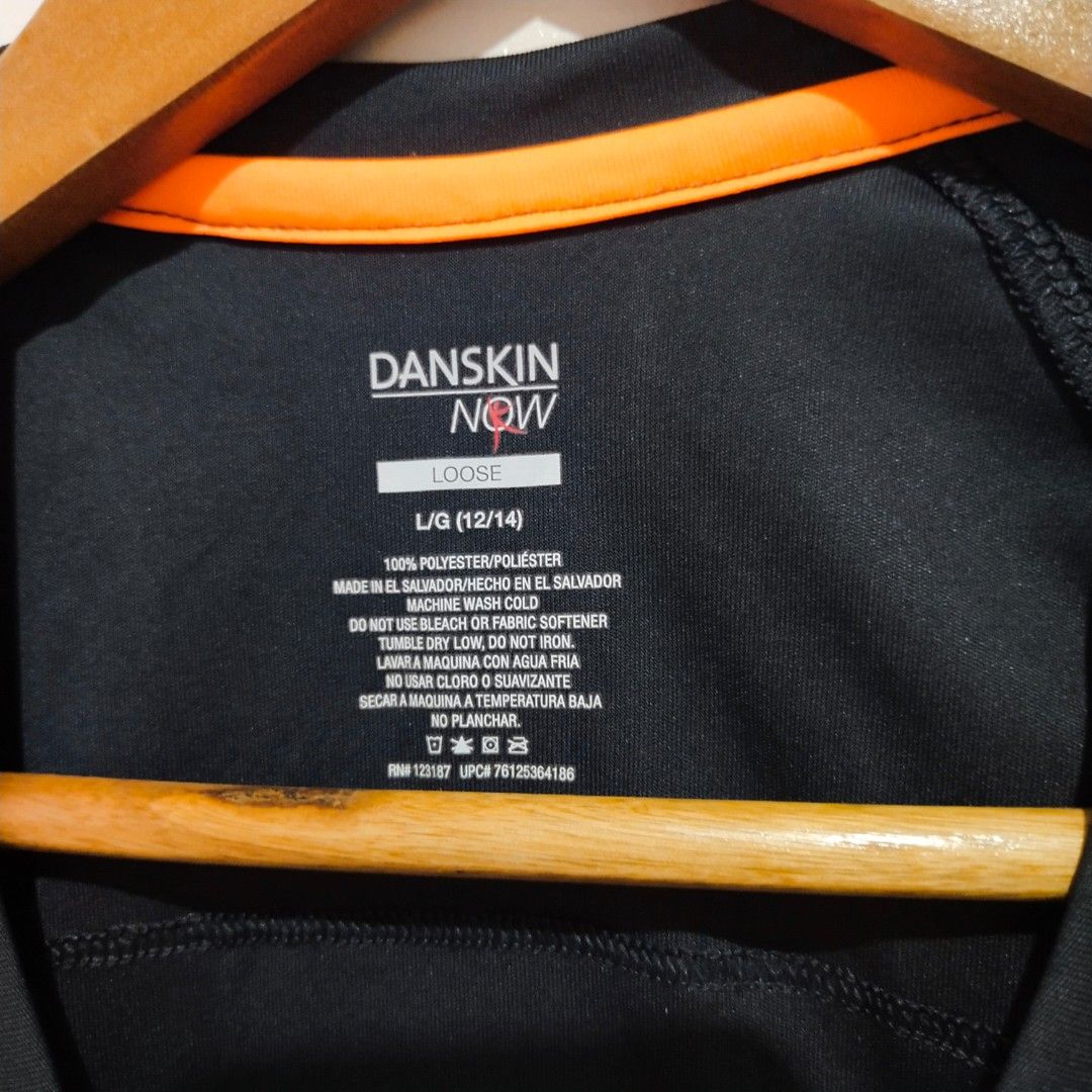Danskin Now Black Athletic V-Neck Shirt (Category: Activewear) located in Subic. Submitted by mustardt_ (Listing ID 1461627741, Image 2). Description: Activewear V-neck top in solid dark charcoal/black with neon orange collar trim, short sleeves, and 100% polyester lightweight dry-release fabric (Size L/G 12/14) size:19in x 25in code: c728.