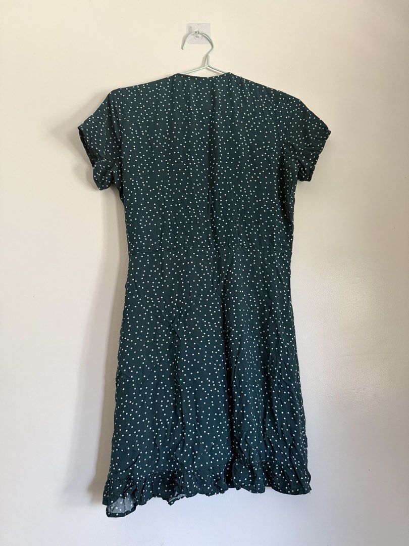 Dark Green Polka Dot Wrap Dress (Category: Dresses) located in Laoag. Submitted by rhedgejasm73385 (Listing ID 1461693435, Image 2). Description: - Adorable dark green dress with classic white polka dots. - Flattering wrap style with comfortable short sleeves. - Chic ruffled hemline for a touch of flair. - Versatile: great for casual outings or dressing up. - Easy to tie and adjust for a perfect fit..