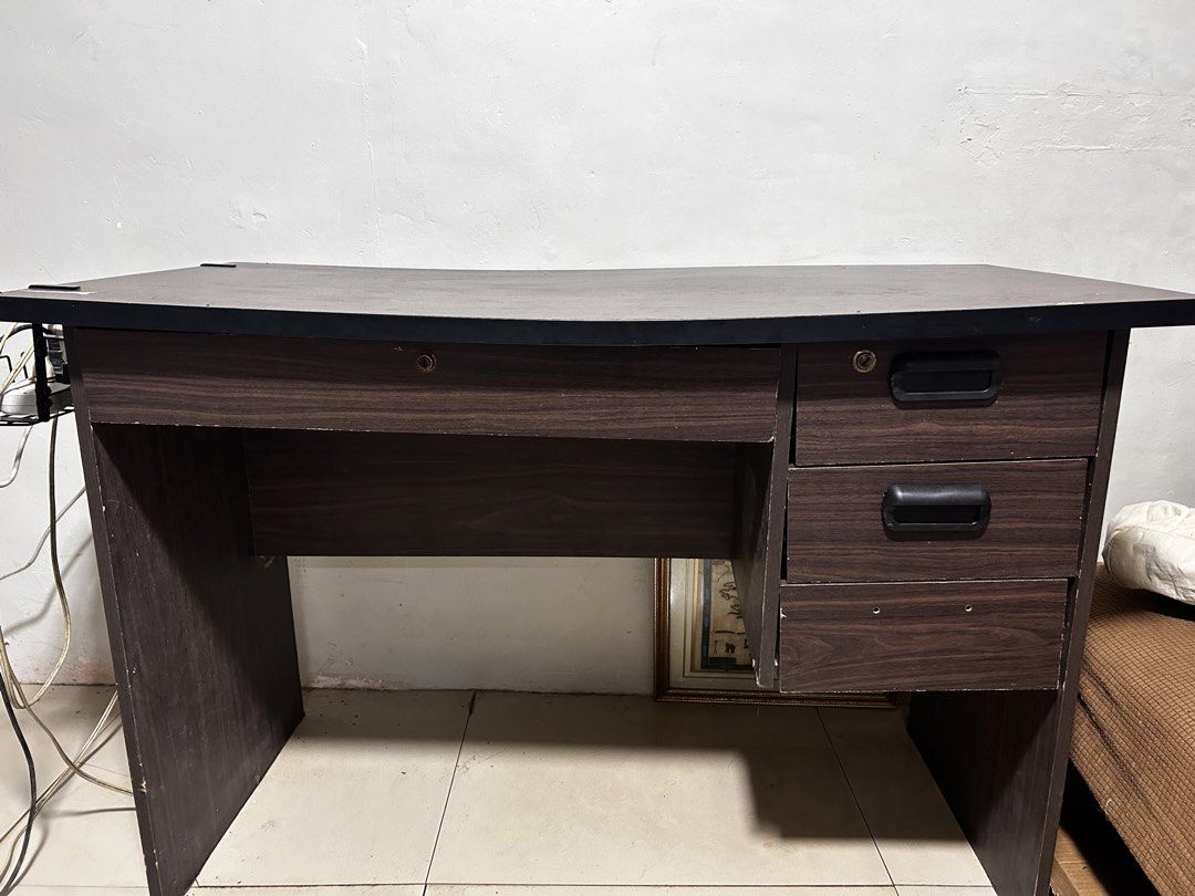 Dark Wood Study Desk with Drawers (Category: Tables & Sets) located in Caloocan City. Submitted by hansev (Listing ID 1461766274, Image 1). Description: - Dimension: L- 117cm, W-53cm, H- 72cm - Stylish dark wood finish study desk - Spacious tabletop for ample workspace - Three convenient drawers on the right side for storage - One drawer includes a lock for added security - Ideal for your home office or study room setup Issue: - Minor scuffs on t