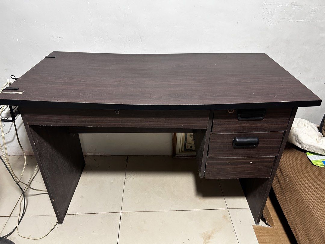 Dark Wood Study Desk with Drawers (Category: Tables & Sets) located in Caloocan City. Submitted by hansev (Listing ID 1461766274, Image 2). Description: - Dimension: L- 117cm, W-53cm, H- 72cm - Stylish dark wood finish study desk - Spacious tabletop for ample workspace - Three convenient drawers on the right side for storage - One drawer includes a lock for added security - Ideal for your home office or study room setup Issue: - Minor scuffs on t