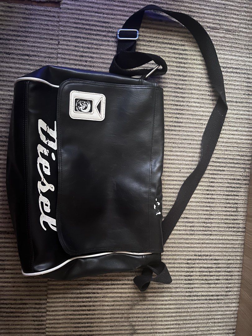 Diesel Black Messenger Bag (Category: Sling Bags) located in Manila. Submitted by d5deleonn50995 (Listing ID 1461649679, Image 1). Description: CAN NEGO - Authentic Diesel messenger bag - Features prominent Diesel logo on the front flap - Adjustable strap for comfortable wear - Chic white piping detail around the edges - Ideal size for everyday essentials.