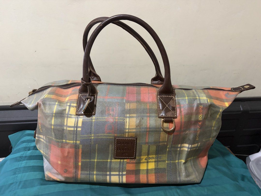 ❤️❤️❤️Dooney & Bourke Plaid Duffle Bag (Project Bag) (Category: Luxury Bags & Wallets) located in Las Pinas. Submitted by ces0427 (Listing ID 1461659565, Image 1). Description: - Cute Dooney & Bourke duffle bag - Colorful plaid pattern - Leather handles and trim - Zipper closure - Signature duck charm included - Ideal for weekend trips or carry-on luggage - Shows some wear on handles and trim, but plenty of life left. please manage your expectatı