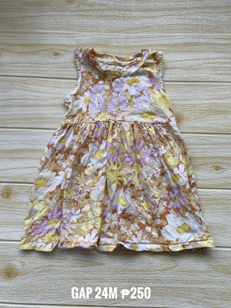 Gap floral dress (Category: Babies & Kids Fashion) located in Cebu City. Submitted by yjainani (Listing ID 1461649436, Image 1). Description: featuring a vibrant yellow, white, and purple floral pattern with a bold purple GAP logo across the chest..