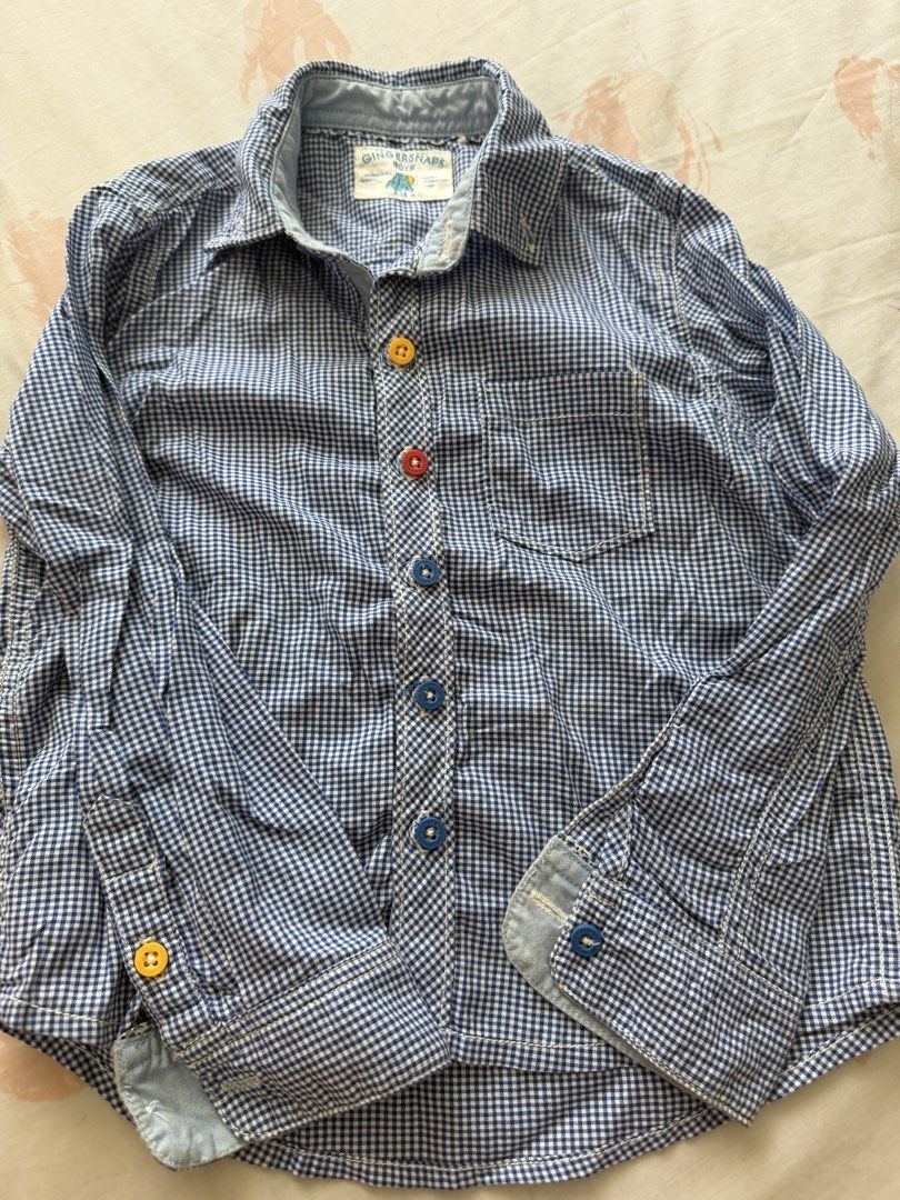 Gingersnaps Boys Blue Gingham Button-Up Shirt Size 4 (Category: Babies & Kids Fashion) located in Manila. Submitted by fitandshop (Listing ID 1461576414, Image 2). Description: - Cute blue gingham button-up shirt - Brand: Gingersnaps - Features colorful buttons on front and cuffs - Material: 100% Cotton - Perfect for casual wear.