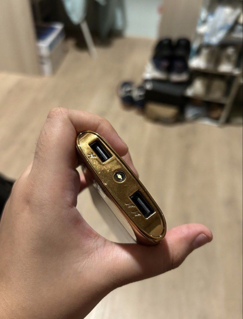 Gold Powerbank w/ Dual USB Output & Flashlight (Category: Batteries & Power Banks) located in Manila. Submitted by potchistrwbrry (Listing ID 1461703683, Image 3). Description: Product Name: Gold Powerbank w/ Dual USB Output & Flashlight Features: * High-capacity 10,000mAh Li-Polymer battery * Dual USB output for simultaneous charging * Fast charging support with up to 2.1A output * Intelligent LCD digital display * Flashlight (long press) Packag