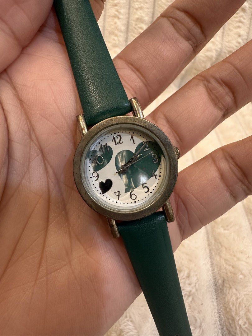 Green Heart Watch (Category: Women's Watches) located in Pasig City. Submitted by surplusatbp (Listing ID 1461563969, Image 2). Description: Green Heart Watch Description: Charming and playful casual watch featuring an eye-catching green heart motif dial. Case Size: 27.3 mm | Wrist Size: Fits up to 17 cm Features & Selling Points: * Whimsical white dial adorned with large green and metallic heart accents. * Clear Arabic numeral hour markers paire