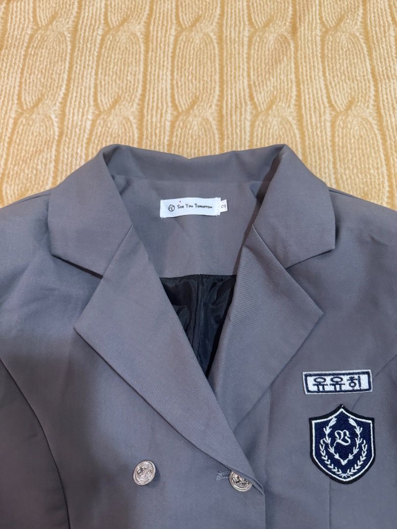 Grey Cropped Double-Breasted Blazer with Patch (Category: Coats, Jackets and Outerwear) located in Calasiao. Submitted by clothesbykim (Listing ID 1461699675, Image 2). Description: - Grey cropped blazer - Double-breasted style - Silver button details - Patch on left chest with Korean text and crest - School uniform-inspired design - Short length, very chic - Ideal for layering.