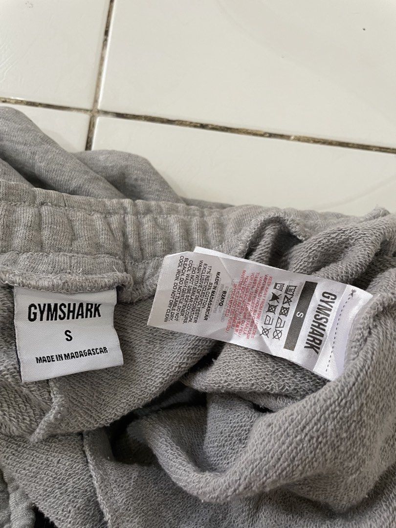 Grey Gymshark Sweatpants Size S (Category: Joggers) located in Siniloan. Submitted by rethr1ft (Listing ID 1461603664, Image 3). Description: - 30-32 waist / 37 length - Brand: Gymshark - Color: Grey - Size: S - Material: Made in Madagascar - Features: Embroidered Gymshark logo on left leg, elastic waistband with drawstring, cuffed ankles - Condition: Minor flaw - small hole on the right leg cuff (refer to last photo for details).