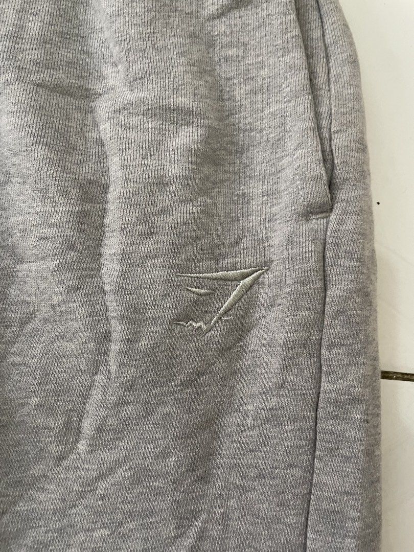 Grey Gymshark Sweatpants Size S (Category: Joggers) located in Siniloan. Submitted by rethr1ft (Listing ID 1461603664, Image 2). Description: - 30-32 waist / 37 length - Brand: Gymshark - Color: Grey - Size: S - Material: Made in Madagascar - Features: Embroidered Gymshark logo on left leg, elastic waistband with drawstring, cuffed ankles - Condition: Minor flaw - small hole on the right leg cuff (refer to last photo for details).