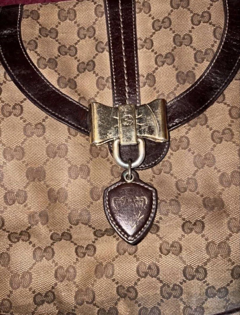 Gucci Monogram Canvas Shoulder Bag (Category: Luxury Bags & Wallets) located in Manila. Submitted by danieysn (Listing ID 1461581926, Image 3). Description: - Authentic Gucci shoulder bag - Classic GG monogram canvas - Dark brown leather trim - Gold-tone bow hardware detail - Heart-shaped charm - Gucci logo lining interior - Comes with dust bag -Includes authenticity cards - Recently had it serviced (bag conditioner) Issues: Signs of usage, scrat