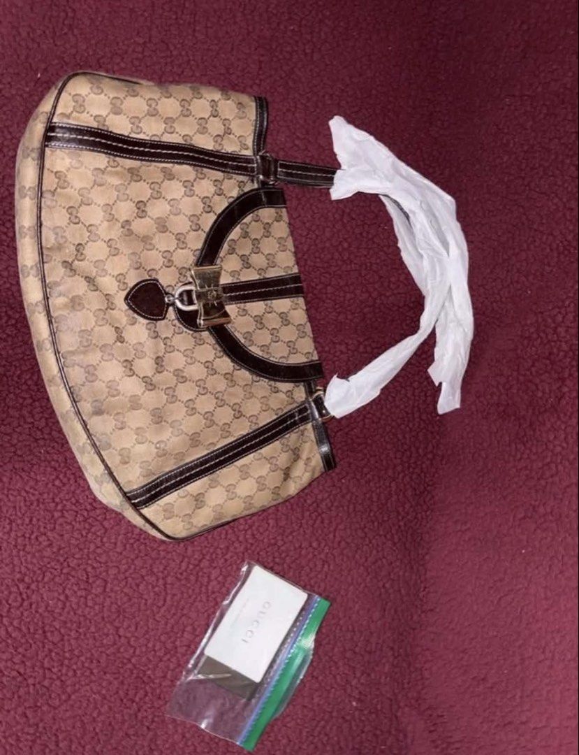 Gucci Monogram Canvas Shoulder Bag (Category: Luxury Bags & Wallets) located in Manila. Submitted by danieysn (Listing ID 1461581926, Image 2). Description: - Authentic Gucci shoulder bag - Classic GG monogram canvas - Dark brown leather trim - Gold-tone bow hardware detail - Heart-shaped charm - Gucci logo lining interior - Comes with dust bag -Includes authenticity cards - Recently had it serviced (bag conditioner) Issues: Signs of usage, scrat