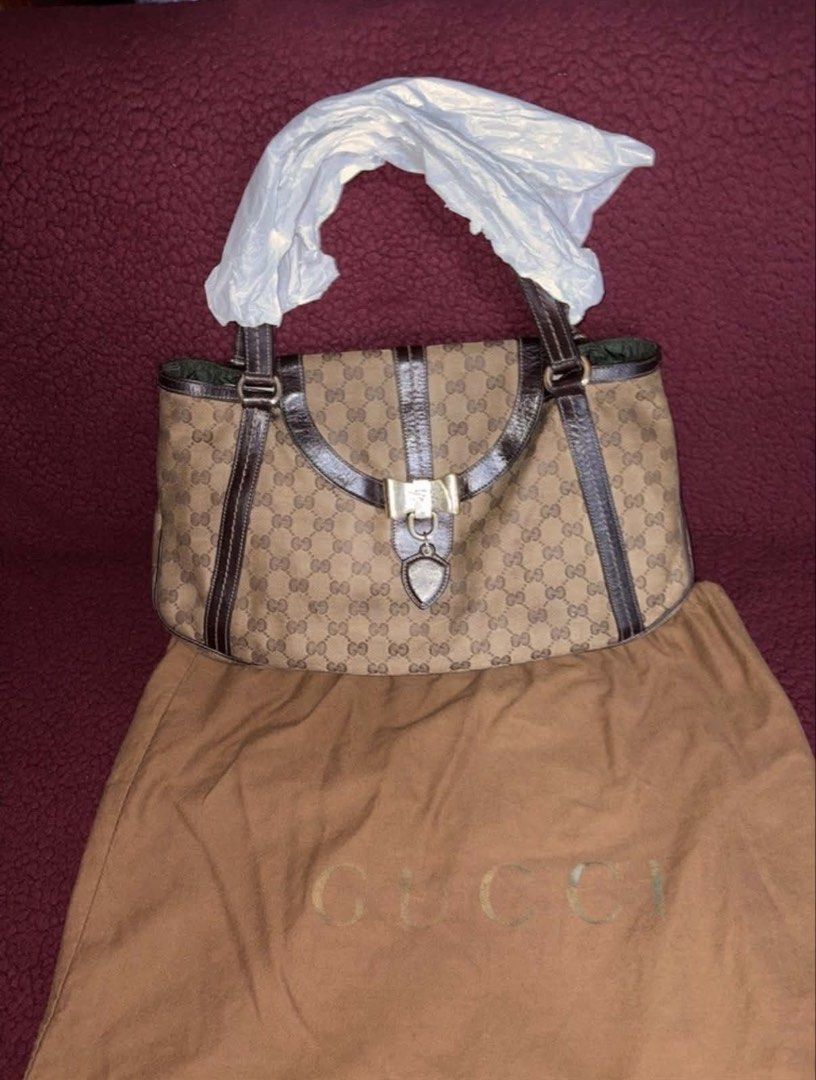 Gucci Monogram Canvas Shoulder Bag (Category: Luxury Bags & Wallets) located in Manila. Submitted by danieysn (Listing ID 1461581926, Image 1). Description: - Authentic Gucci shoulder bag - Classic GG monogram canvas - Dark brown leather trim - Gold-tone bow hardware detail - Heart-shaped charm - Gucci logo lining interior - Comes with dust bag -Includes authenticity cards - Recently had it serviced (bag conditioner) Issues: Signs of usage, scrat