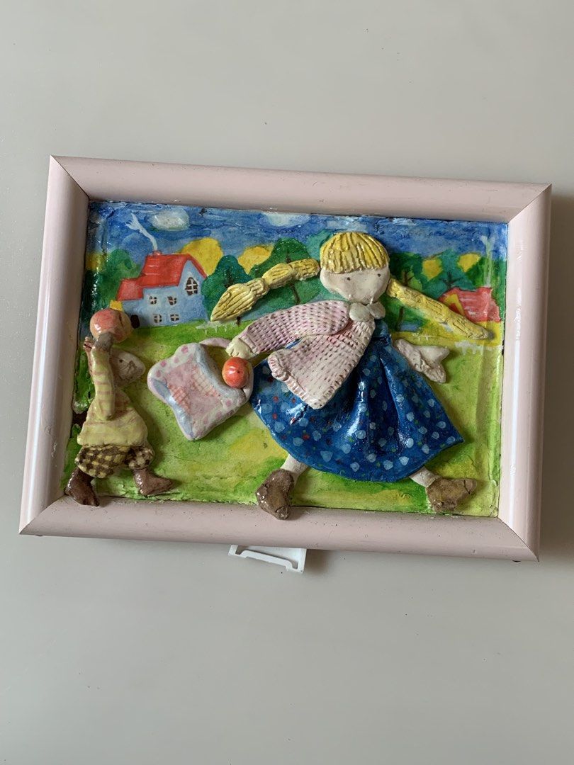 Handmade 3D Paper Clay Wall Art/ Frame (Category: Frames & Pictures) located in Tandag. Submitted by jeason_22 (Listing ID 1461623219, Image 1). Description: This charming handmade 3D paper clay wall art features a blonde-braided girl in a blue dress carrying a patterned bag in a vibrant pastoral landscape. Dimension: 5 x 6 inches Condition: may bak-bak sa left side bottom ( see photo ).