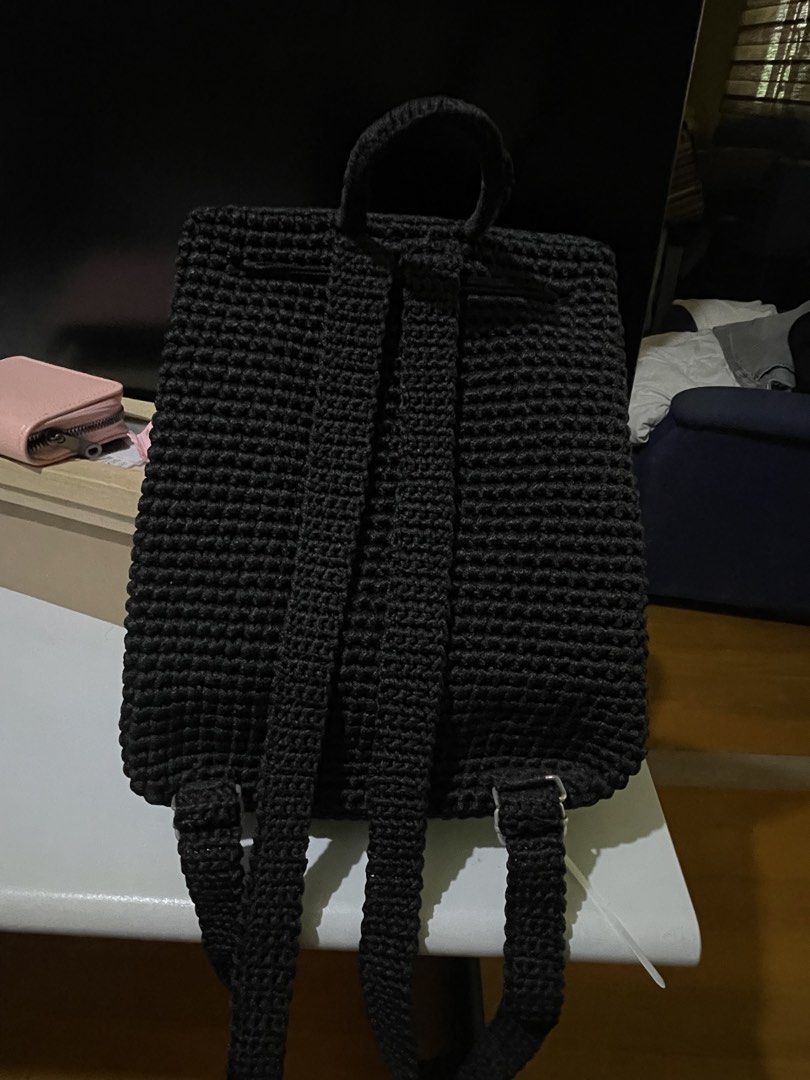 Handmade Black Crocheted Backpack (Category: Backpacks) located in Santa Cruz. Submitted by lilpurpleseven (Listing ID 1461573733, Image 3). Description: - Handmade black crocheted backpack - Secure drawstring closure with a flap and wooden button - Unique blue crocheted initial 'J' on the front - Adjustable straps for comfortable wear - Ideal for everyday use or as a thoughtful gift.