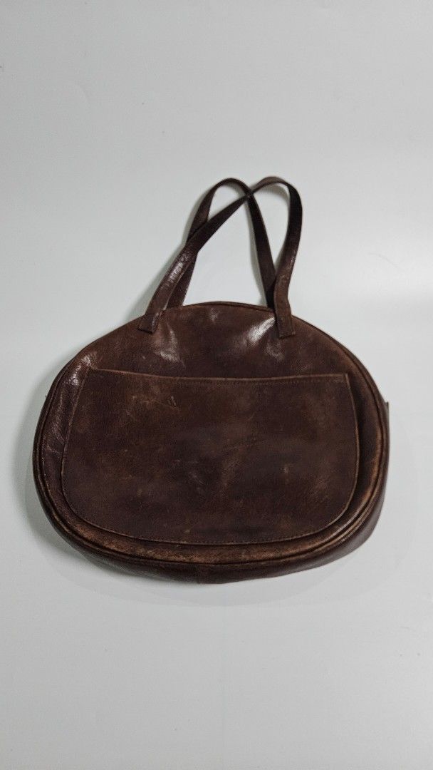 Hane Hands Brown Leather Shoulder Bag (Category: Shoulder Bags) located in Alfonso. Submitted by jbcamet (Listing ID 1461713316, Image 2). Description: - Brand: Hane Hands - Material: Genuine Leather - Color: Brown - Exterior Features: Two front pockets, one with a zipper - Interior Features: Suede lining, one zippered pocket - Condition: Shows a lovely patina from use, indicating character and quality - Straps: Comfortable for shoulder carrying 