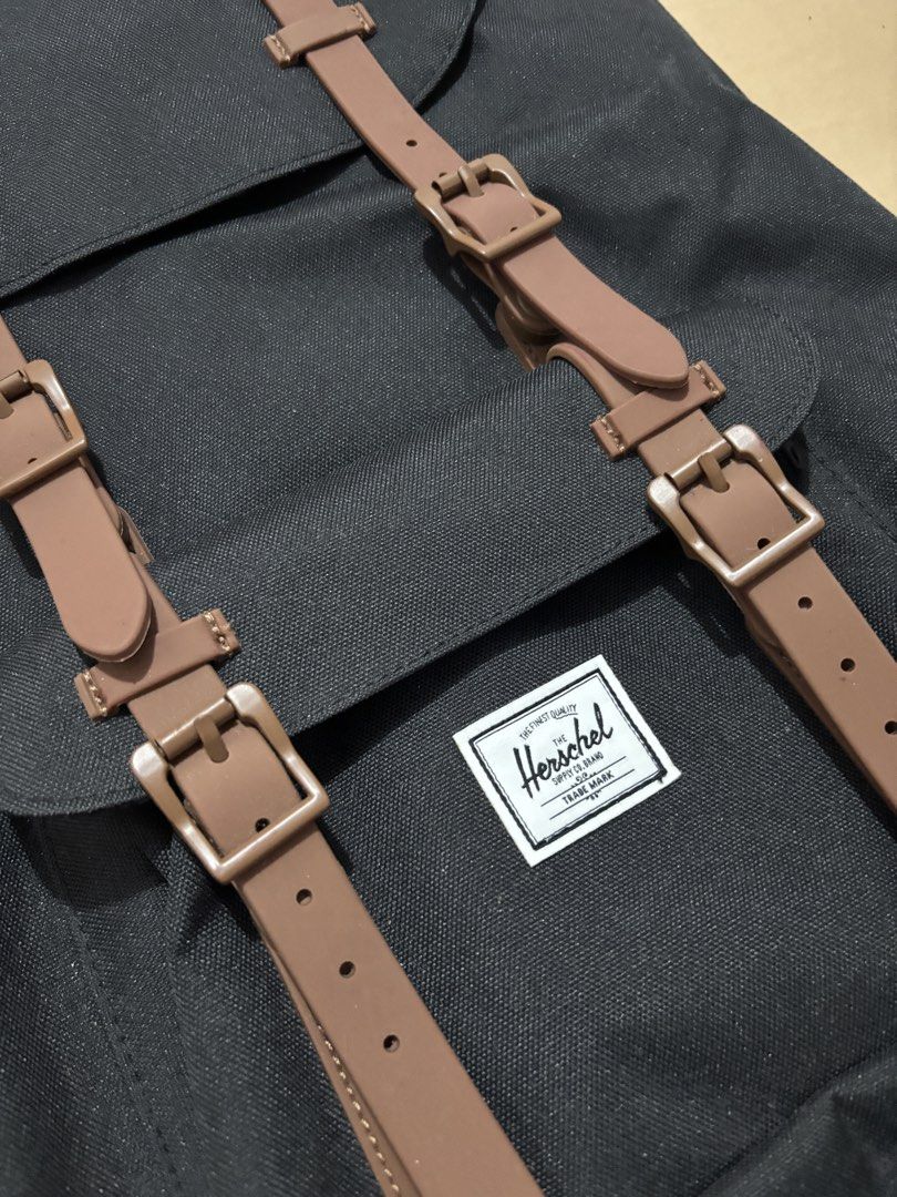 Herschel Little America Backpack Black (Category: Backpacks) located in Lucban. Submitted by quinsdollhouse (Listing ID 1461665766, Image 2). Description: - Classic black Herschel backpack - Brown faux leather straps with buckle closures - Signature red and white striped interior lining - Spacious main compartment for essentials - Adjustable padded shoulder straps for comfort - Just needs cleaning - Ideal for school, work, or everyday carry.