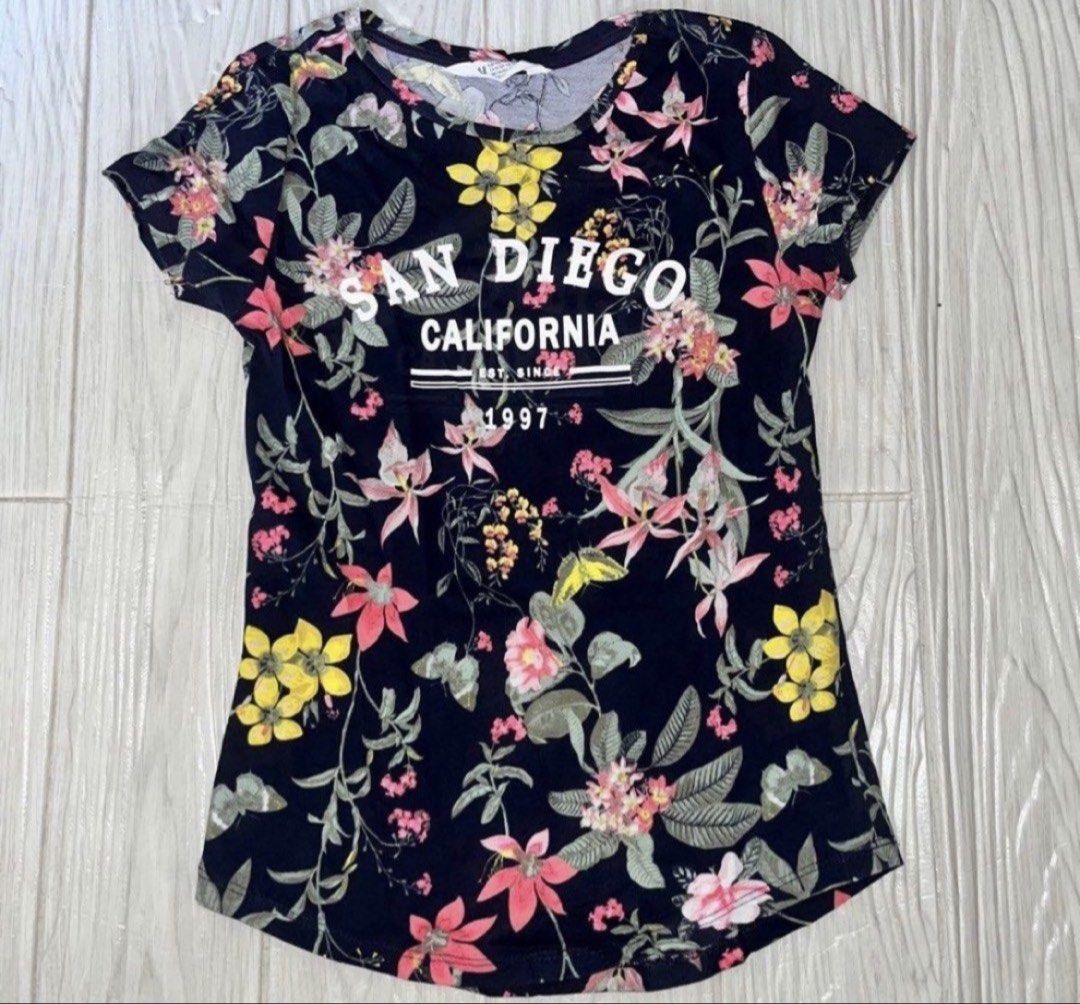 H&M Floral Tshirt 10-12yo (Category: Babies & Kids Fashion) located in Rizal. Submitted by cassappl (Listing ID 1461681630, Image 1). Description: - Navy blue t-shirt - Vibrant floral print - 'San Diego California Est. Since 1997' graphic on front - Short sleeves - Comfortable fit - Ideal for casual wear or as a souvenir.