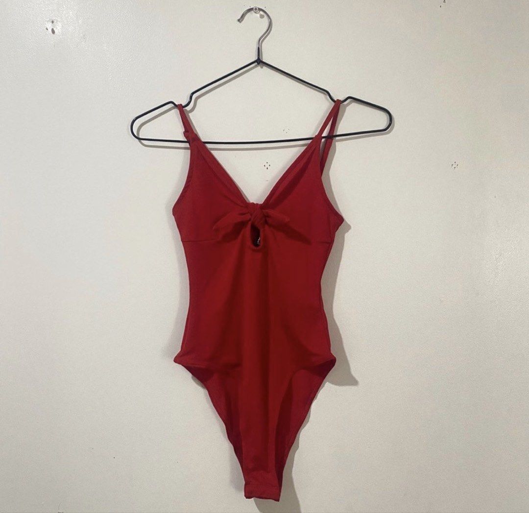 H&M Red Twisted Sexy Bodysuit (Category: Sleeveless) located in Binan City. Submitted by mypreloved_haul (Listing ID 1461693090, Image 1). Description: The item in the image is an H&M red tie-front cutout one-piece bodysuit/swimsuit. It features a V-neck plunge neckline, thin adjustable spaghetti straps, a functional or decorative front tie knot, and a small teardrop keyhole cutout at the chest..