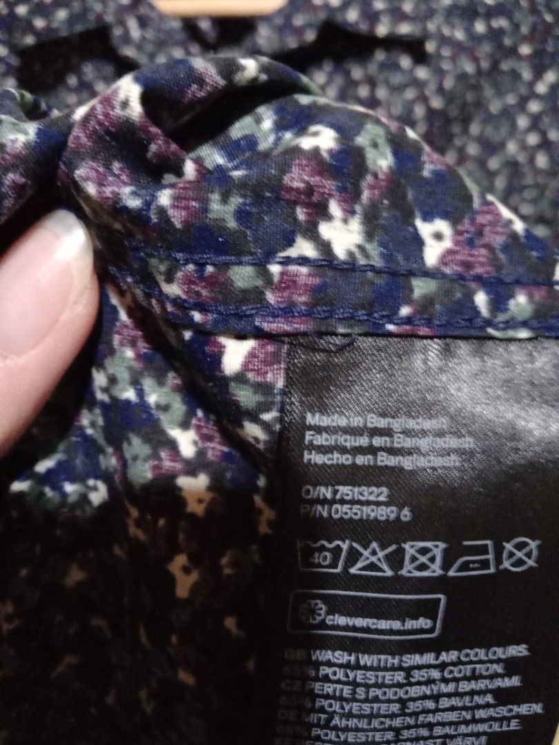 H&M Slim Fit Printed Shirt (Category: Tshirts & Polo Shirts ) located in San Fernando. Submitted by _luxielleph (Listing ID 1461797032, Image 3). Description: - H&M Slim Fit Shirt - Base Color: Dark Blue - Print: White and Purple Floral - Style: Long Sleeves, Button-Up Front - Material: Cotton and Polyester Blend - Feature: Easy Iron Fabric - Occasion: Casual or Smart-Casual Wear - Sizing: Please check the size label in the photos.