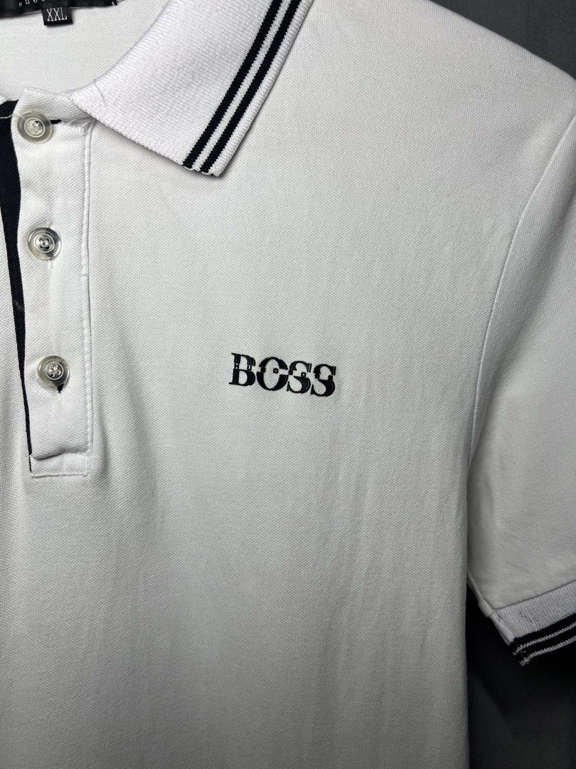 HUGO BOSS White Polo Shirt (Category: Tshirts & Polo Shirts ) located in Luna. Submitted by lareign (Listing ID 1461589908, Image 2). Description: - White HUGO BOSS polo shirt - Black striped collar and sleeve cuffs - Small BOSS logo on chest - Larger HUGO BOSS logo on sleeve -Best fits men's size S -Rubber embossed/ print - Great for unisex wear.