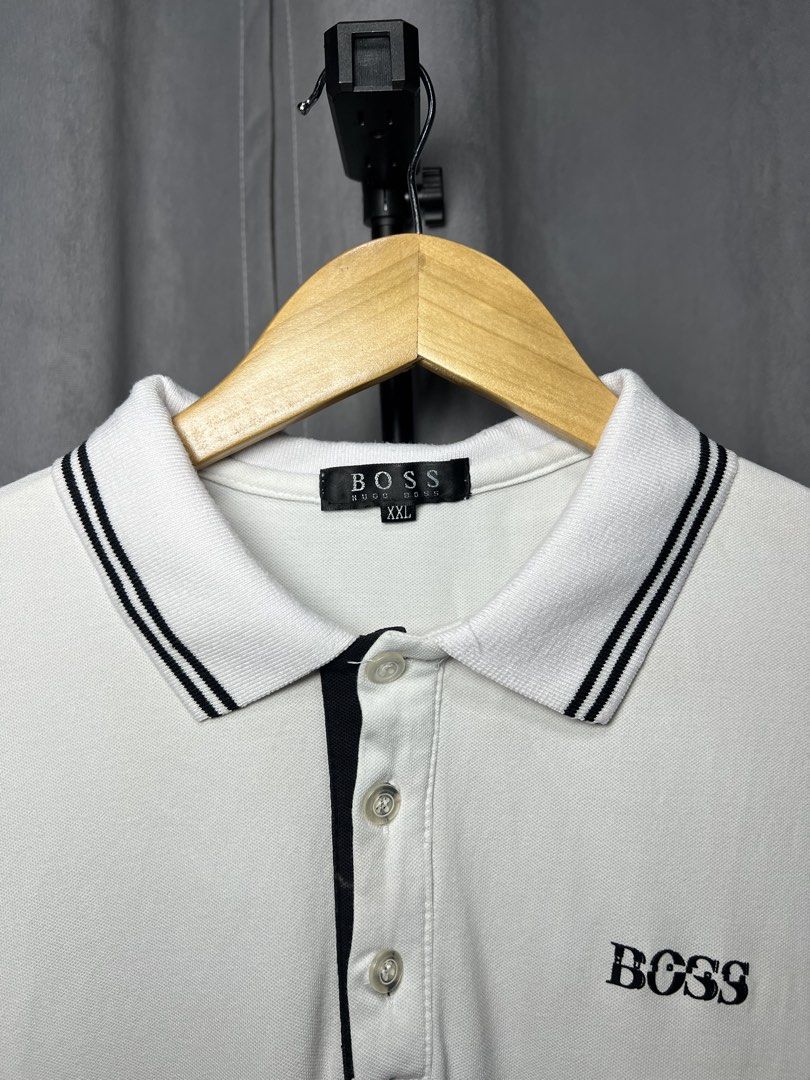 HUGO BOSS White Polo Shirt (Category: Tshirts & Polo Shirts ) located in Luna. Submitted by lareign (Listing ID 1461589908, Image 3). Description: - White HUGO BOSS polo shirt - Black striped collar and sleeve cuffs - Small BOSS logo on chest - Larger HUGO BOSS logo on sleeve -Best fits men's size S -Rubber embossed/ print - Great for unisex wear.