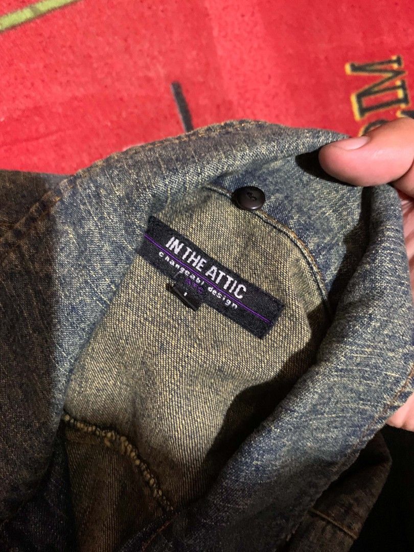 IN THE ATTIC DISTRESSED ZIP-UP DENIM JACKET (Category: Coats, Jackets and Outerwear) located in Davao. Submitted by thrift_cuttiiee1000 (Listing ID 1461712221, Image 3). Description: Design & Features: Distressed Aesthetic: Heavily faded, worn-in blue denim with shredded (distressed) details throughout . Utility & Punk Hardware: Metal pyramid studs above the chest, zippers, decorative pull-ties, and distinctive oversized metallic grommets/eyelets