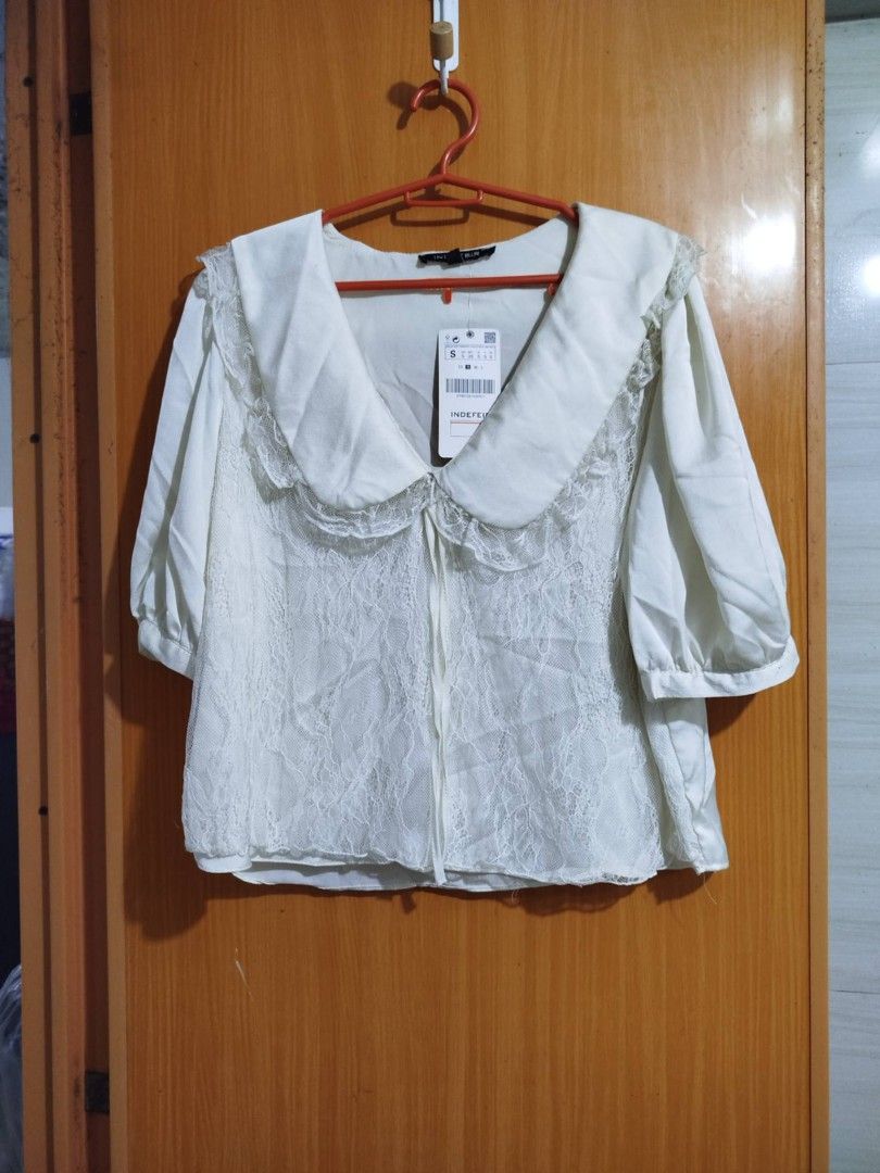 INDEFIR White Lace Peter Pan Collar Blouse Size S (Category: Blouses) located in Quezon City. Submitted by niceoutfits (Listing ID 1461599989, Image 1). Description: - Brand new white blouse with tags attached ( old stock need washing ) - Delicate lace overlay - Charming large Peter Pan collar - Adjustable neck ties - Puffy sleeves with buttoned cuffs - Versatile for cute, vintage-inspired outfits.