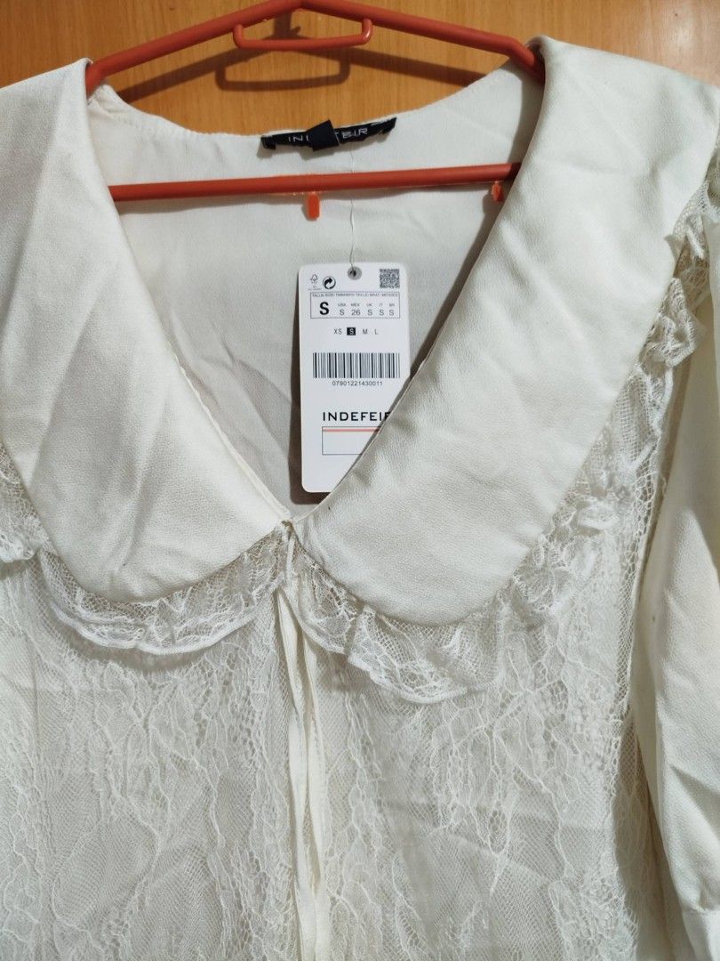 INDEFIR White Lace Peter Pan Collar Blouse Size S (Category: Blouses) located in Quezon City. Submitted by niceoutfits (Listing ID 1461599989, Image 2). Description: - Brand new white blouse with tags attached ( old stock need washing ) - Delicate lace overlay - Charming large Peter Pan collar - Adjustable neck ties - Puffy sleeves with buttoned cuffs - Versatile for cute, vintage-inspired outfits.