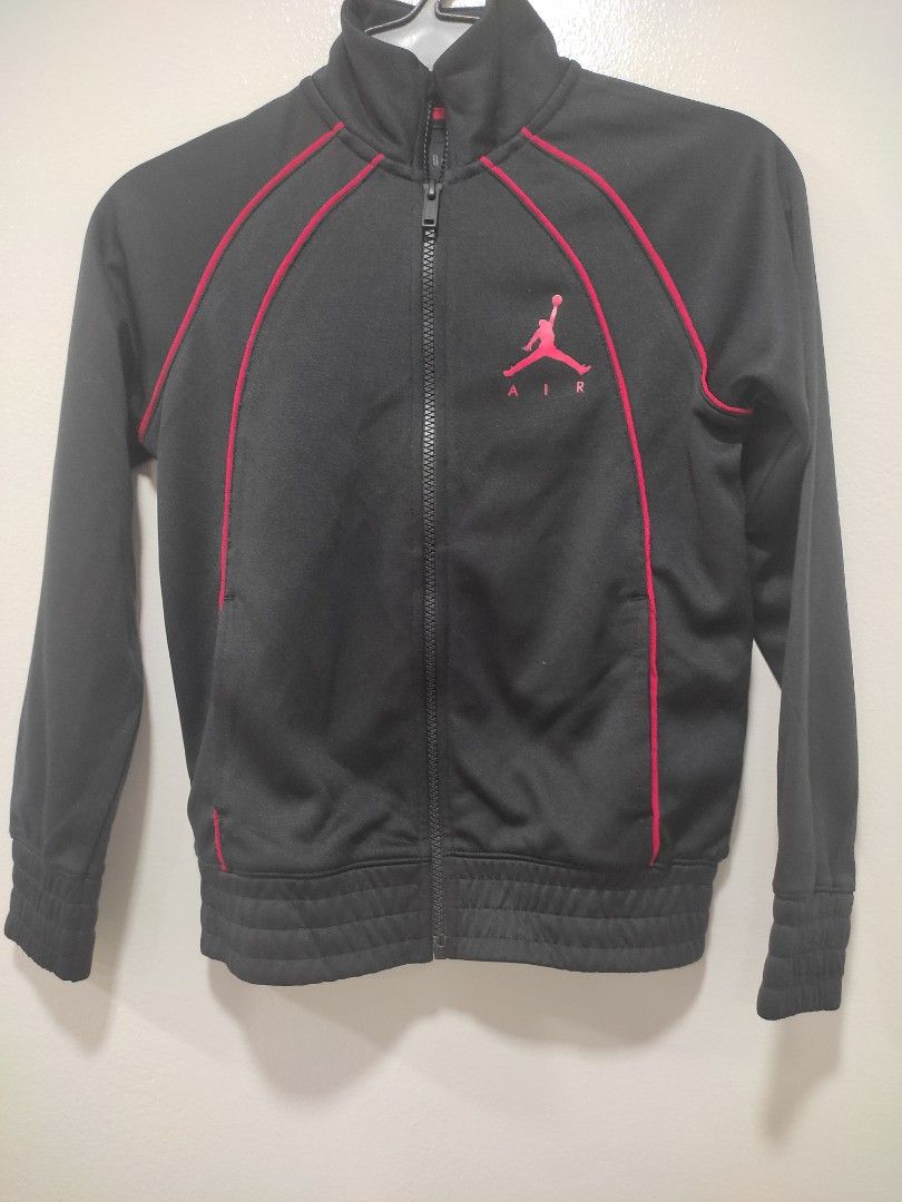 Jordan Air Track Jacket Black Red (Category: Babies & Kids Fashion) located in Pasay City. Submitted by mirabrie (Listing ID 1461568482, Image 1). Description: - Classic black Jordan track jacket - Bold red piping detail - Iconic Jumpman logo and 'AIR' text - Full zip closure for easy wear - Ribbed cuffs and hem for a snug fit - Ideal for both casual outings and athletic activities.