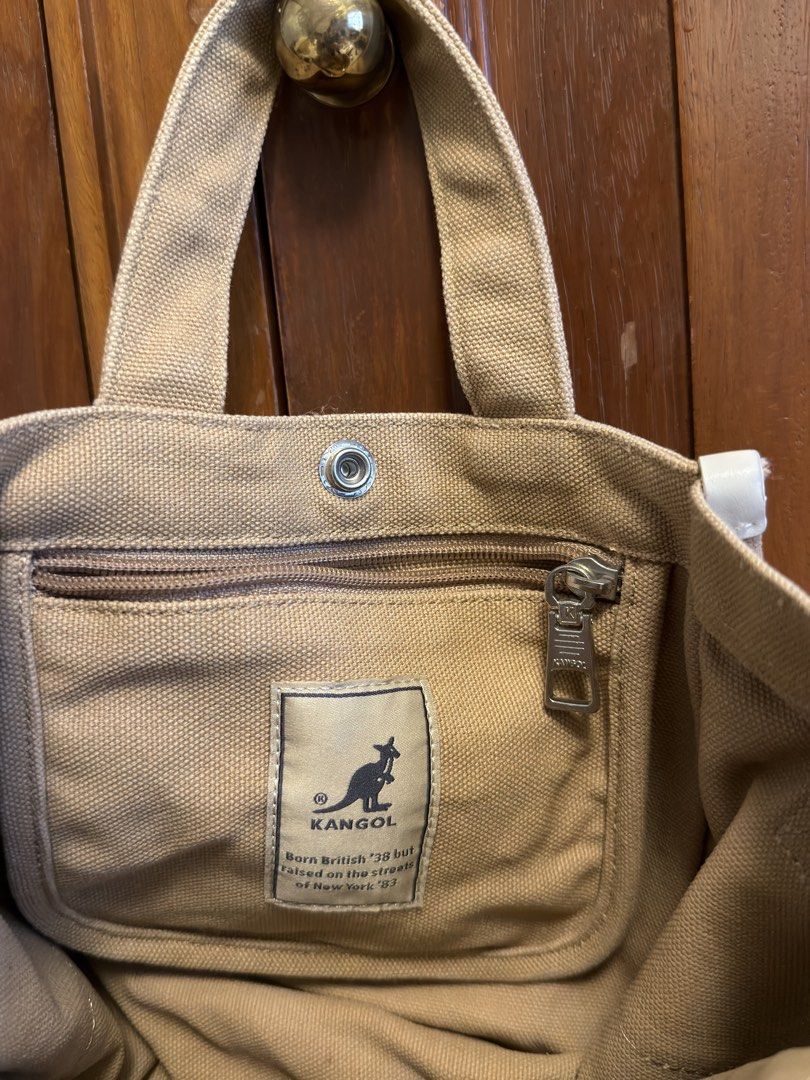 Kangol Canvas Small Tote Bag with Sling (Category: Tote Bags) located in Tarlac. Submitted by jzennoroyy-32960 (Listing ID 1461605614, Image 2). Description: - Brand: Kangol - Color: Tan - Material: Canvas - Style: Tote Bag - Features: Top handles, detachable crossbody strap, compartment, interior zip pocket, small kangaroo logo on front - Ideal for: Everyday use.