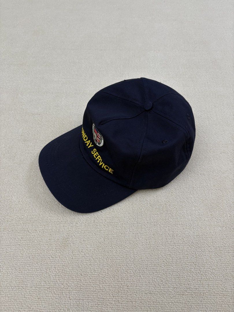 Kanye West sunday service hat (Category: Caps & Hats) located in Manila. Submitted by porma.market (Listing ID 1461577759, Image 3). Description: - Navy blue baseball cap - Features 'SUNDAY SERVICE' embroidered in yellow on the front - Includes a circular logo above the text - 'MADE IN USA' tag inside - Simple and classic design.