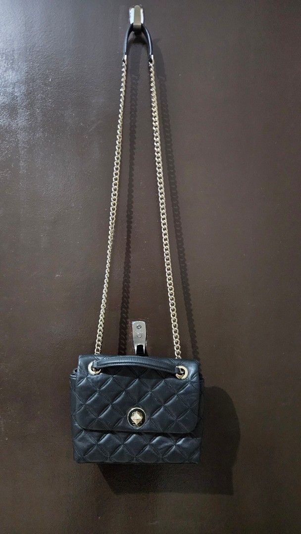 Kate Spade Black Quilted Leather Chain Shoulder Bag (Category: Luxury Bags & Wallets) located in Quezon City. Submitted by gabrielscloset (Listing ID 1461652940, Image 3). Description: - Brand: Kate Spade - Material: Black quilted leather - Hardware: Silver turn-lock closure and chain strap with leather accents - Interior: Black lining with spade pattern - Style: Shoulder bag - Versatile: Ideal for day or night use.