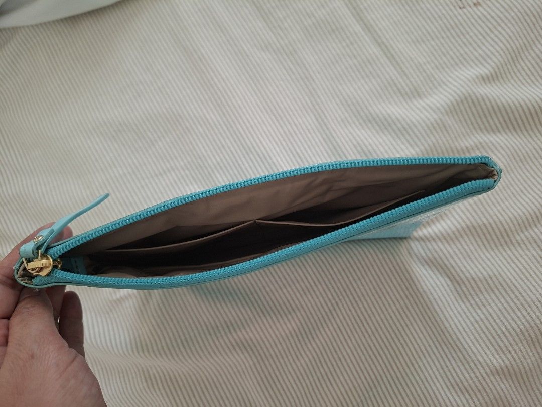 Kate Spade Turquoise Perforated Pouch Clutch (Category: Purses & Pouches) located in Pasig City. Submitted by avcan (Listing ID 1461580107, Image 3). Description: - Authentic Kate Spade pouch in a vibrant turquoise color. - Features a chic all-over perforated pattern. - Secure and fully functional zipper closure. - Interior slip pockets for organization. - Ideal for storing essentials..