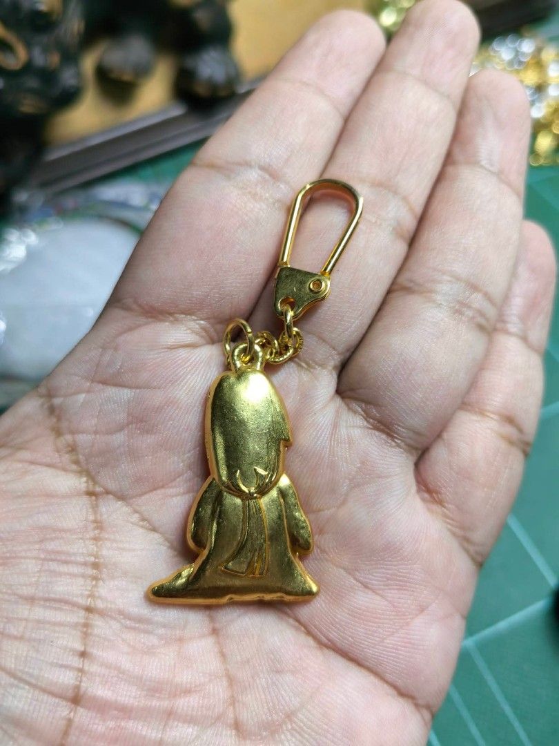 Keychain - Gold-colored Metal Charm or Keychain (Category: Charms) located in Cebu City. Submitted by dudes_villanueva (Listing ID 1461586531, Image 3). Description: Keychain - Gold-colored Metal Charm or Keychain 📌 Shaped like a kneeling figure in a hooded cloak or robe, holding its hands together in a prayer or devotional pose..