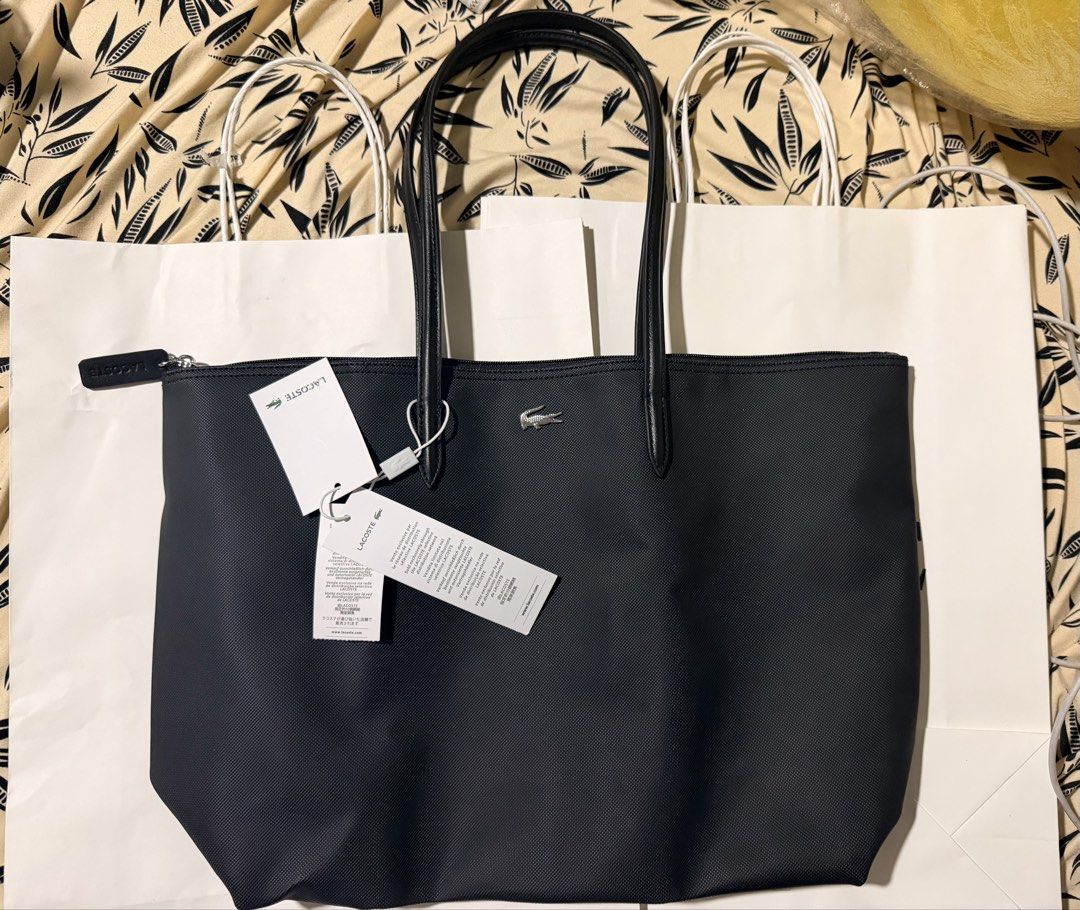 Lacoste Black Tote Bag with Tags (Category: Tote Bags) located in Quezon City. Submitted by pernella (Listing ID 1461726848, Image 1). Description: - Classic black Lacoste tote bag - Features the iconic crocodile logo - Made from durable material for everyday use - Plenty of interior space for essentials - Comfortable handles for easy carrying - Brand new with original tags attached + paperbag -Navy Blue is already sold.