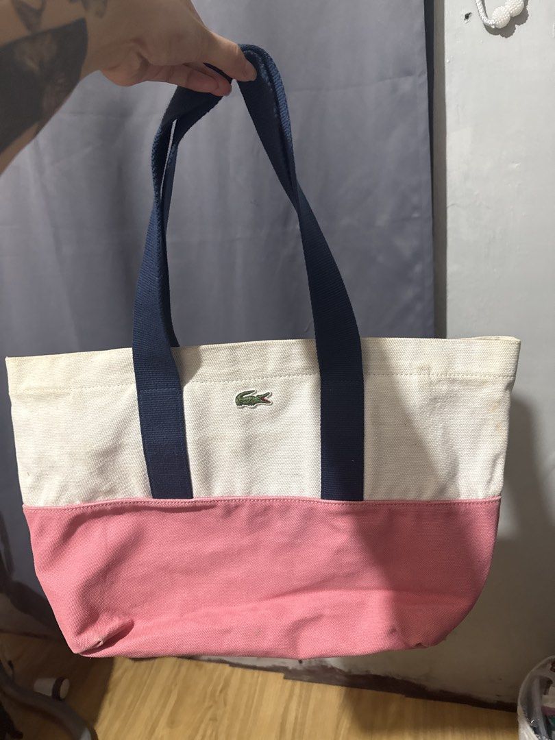 Lacoste Canvas Tote Bag Pink White Navy (Category: Tote Bags) located in Las Pinas. Submitted by yourboki.2026 (Listing ID 1461605977, Image 2). Description: ❌MISSING Small Pouch (actual photo with complete inclusion will be on the last photo) 💯ORIGINAL LACOSTE - Cute Lacoste tote bag - White canvas with pink bottom - Navy blue handles - Inner zip pocket - Great for everyday use - Shows some signs of wear on white canvas - Still has plenty of li