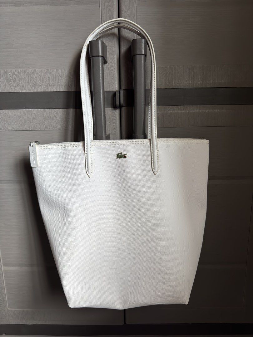 Lacoste White Tote Bag (Category: Tote Bags) located in San Mateo. Submitted by rkg_agbayani (Listing ID 1461596747, Image 1). Description: - Classic white Lacoste tote bag - Features the iconic crocodile logo - Secure zipper closure - Spacious interior for essentials - Comfortable shoulder straps - Ideal for everyday use or travel.
