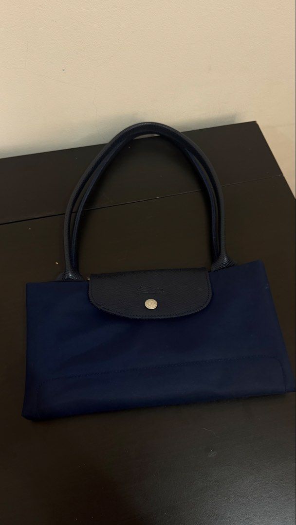 Large Longchamp Le Pliage Leather (Category: Tote Bags) located in Manila. Submitted by jln888 (Listing ID 1461566891, Image 1). Description: Original Large Longchamp Le Pliage Tote Bag in Navy Blue with Care Card - Leather handles and flap closure - Silver-tone zipper pull with Longchamp logo - Spacious interior - Classic design - Longchamp logo on front.