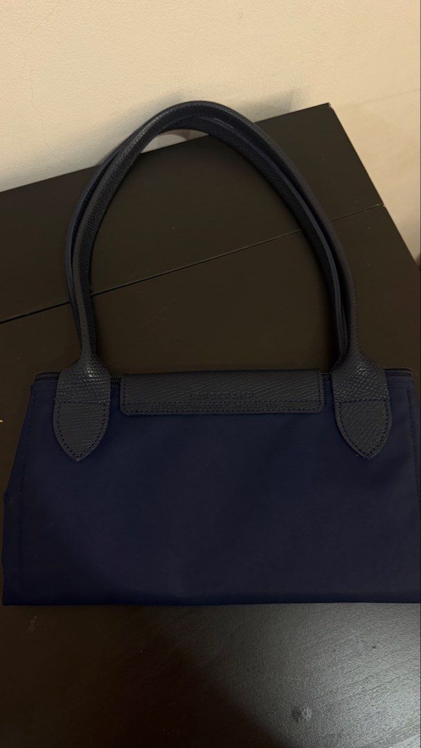 Large Longchamp Le Pliage Leather (Category: Tote Bags) located in Manila. Submitted by jln888 (Listing ID 1461566891, Image 2). Description: Original Large Longchamp Le Pliage Tote Bag in Navy Blue with Care Card - Leather handles and flap closure - Silver-tone zipper pull with Longchamp logo - Spacious interior - Classic design - Longchamp logo on front.