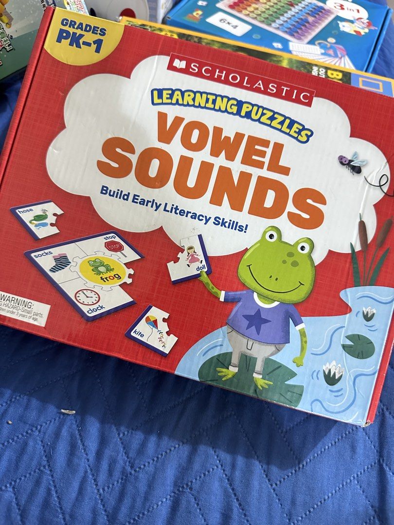 Learning Puzzles for Kids (Category: Infant Playtime) located in Manila. Submitted by jailand08 (Listing ID 1461717906, Image 1). Description: - Brand: Scholastic - Product: Learning Puzzles: Vowel Sounds - Target Age/Grade: PK-1 - Skill Focus: Builds Early Literacy Skills - Features: Engaging puzzles with words like hose, socks, stop, frog, clock, doll, and kite - Design: Colorful and child-friendly with a frog illustration - Educational Value: 