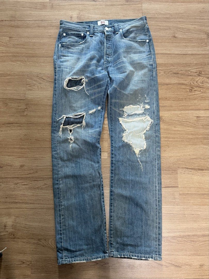 Levi's 501 Distressed Blue Jeans (Category: Jeans) located in Makati City. Submitted by size9pls (Listing ID 1461640017, Image 1). Description: - Classic Levi's 501 jeans - Light blue wash with intentional distressing and rips - Unique striped fabric patch on the right leg - Button fly closure - Ideal for a casual, edgy look Waist 32 Length 42 Hem 8.