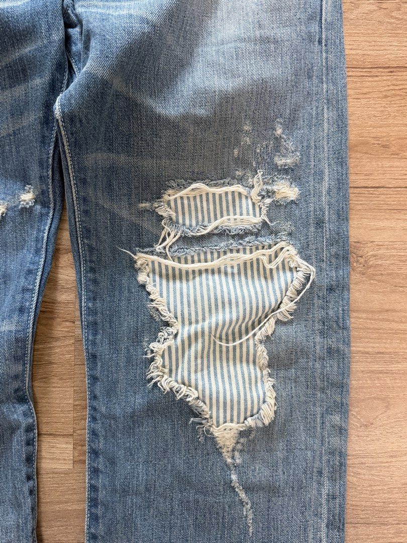 Levi's 501 Distressed Blue Jeans (Category: Jeans) located in Makati City. Submitted by size9pls (Listing ID 1461640017, Image 3). Description: - Classic Levi's 501 jeans - Light blue wash with intentional distressing and rips - Unique striped fabric patch on the right leg - Button fly closure - Ideal for a casual, edgy look Waist 32 Length 42 Hem 8.