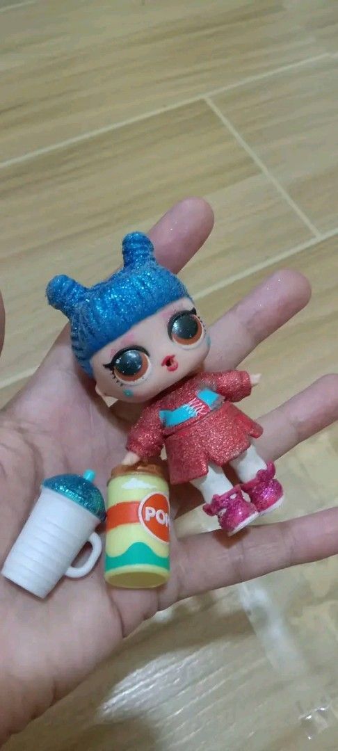 LOL Surprise Doll with Accessories (Category: Kids Toys) located in Gapan. Submitted by montesnora80204 (Listing ID 1461594424, Image 1). Description: - Adorable LOL Surprise doll - Features striking blue glitter hair - Dressed in a sparkly red outfit - Wears cute pink boots - Includes a soda can accessory - Comes with a white cup with a blue lid - Ideal gift for LOL Surprise enthusiasts.