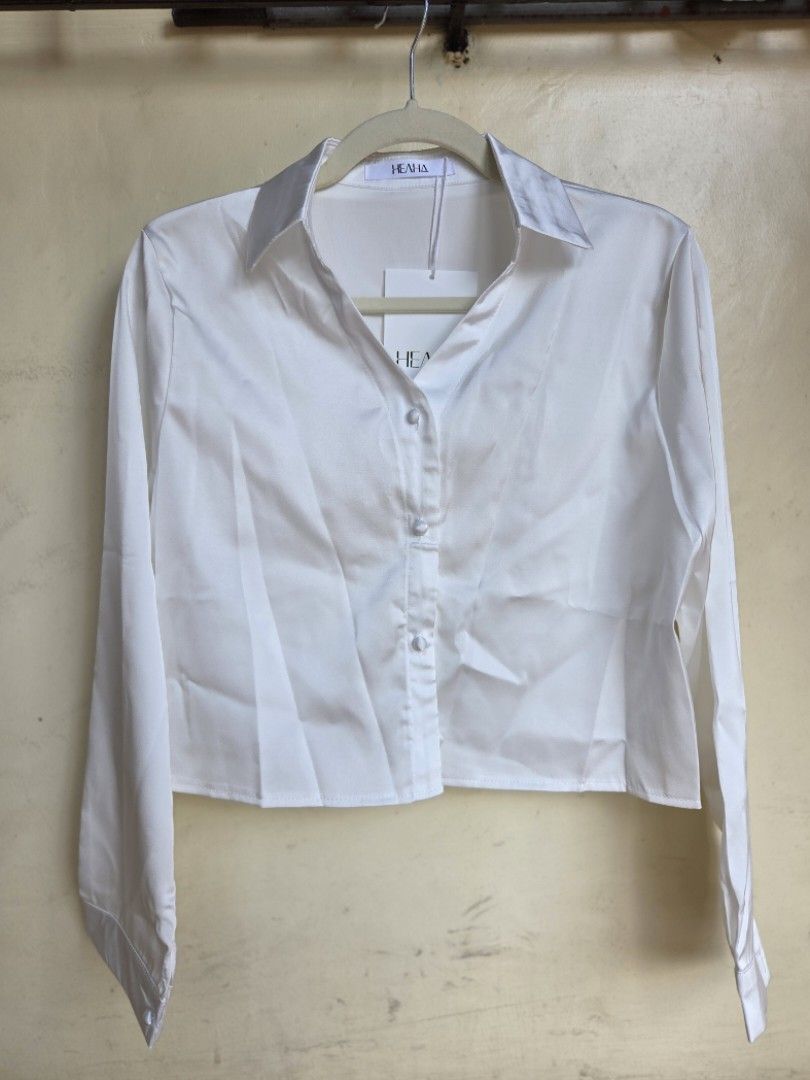 Long-sleeved, white satin button-down (Category: Blouses) located in Agdangan. Submitted by wearitnext.shop (Listing ID 1461563178, Image 2). Description: Long-sleeved satin button-down shirt with a slightly cropped, straight hem. Original Price: 420.