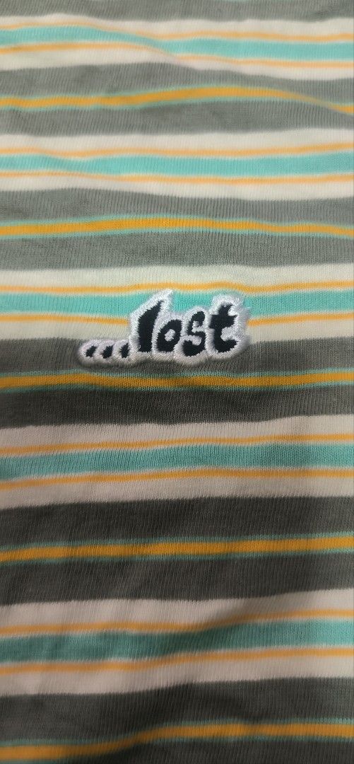 LOST Striped T-Shirt Size M (Category: Tshirts & Polo Shirts ) located in Manila. Submitted by itsmelawrence (Listing ID 1461762677, Image 3). Description: - Brand: LOST - Size: M - Color: Horizontal stripes in grey, green, yellow, and white - Features: Small embroidered LOST logo on chest - Material: 100% Cotton - Origin: Made in India.