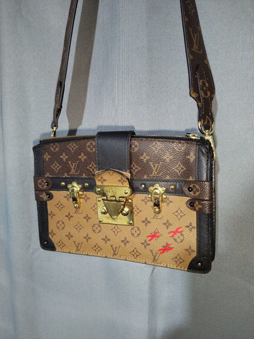 Louis Vuitton Monogram Trunk Clutch Bag (Category: Luxury Bags & Wallets) located in Pasig City. Submitted by loveforlux_2025 (Listing ID 1461589926, Image 2). Description: - Louis Vuitton clutch bag -replaced sling strap - Monogram canvas with black leather trim - Signature LV lock closure - Minor red markings on front canvas - Detachable leather strap - Gold-tone hardware - Some wear on leather strap attachment.