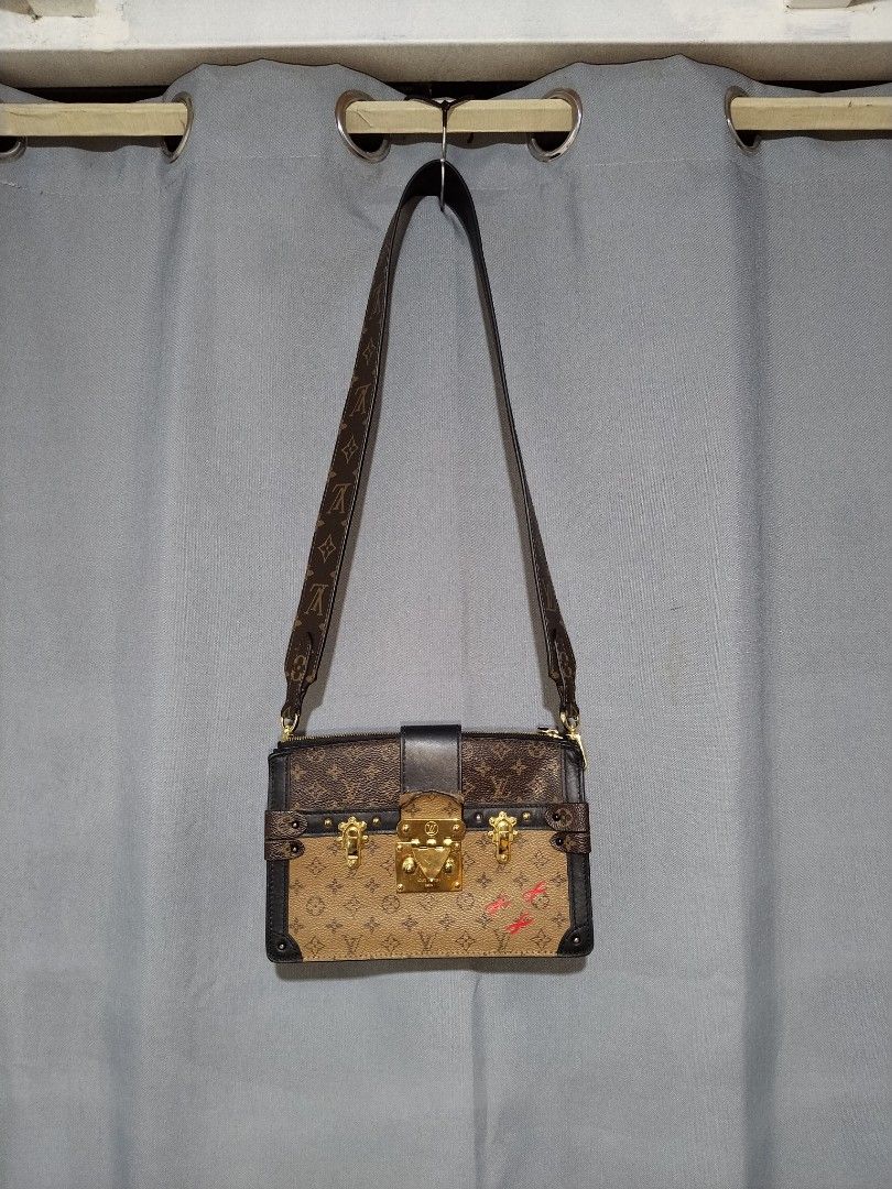 Louis Vuitton Monogram Trunk Clutch Bag (Category: Luxury Bags & Wallets) located in Pasig City. Submitted by loveforlux_2025 (Listing ID 1461589926, Image 1). Description: - Louis Vuitton clutch bag -replaced sling strap - Monogram canvas with black leather trim - Signature LV lock closure - Minor red markings on front canvas - Detachable leather strap - Gold-tone hardware - Some wear on leather strap attachment.