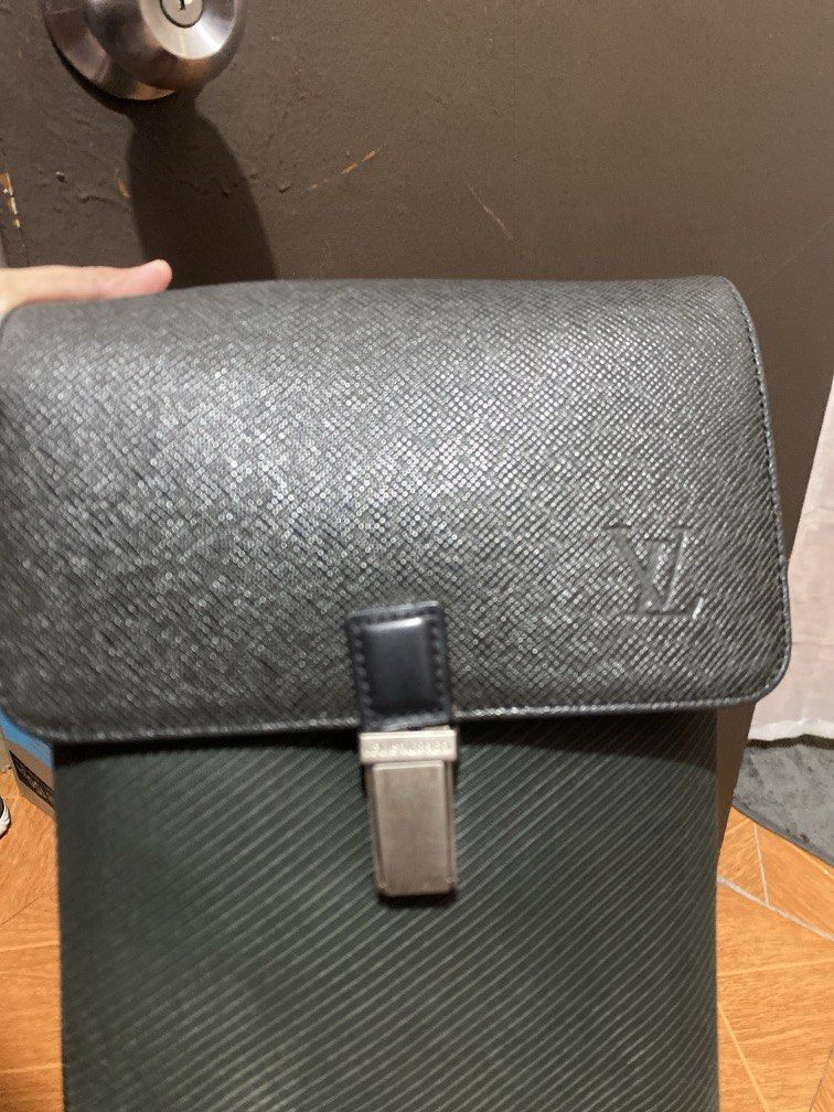 Louis Vuitton Taiga Leather/canvas Sling Bag (Category: Luxury Bags & Wallets) located in Manila. Submitted by junejanuary (Listing ID 1461748187, Image 2). Description: - Louis Vuitton Black Taiga leather clutch - Features iconic LV monogram embossed on the front - Secure clasp closure with Louis Vuitton branding - Perfect for carrying your essentials - Interior is clean and well-maintained - Minor signs of wear on hardware, consistent with norm