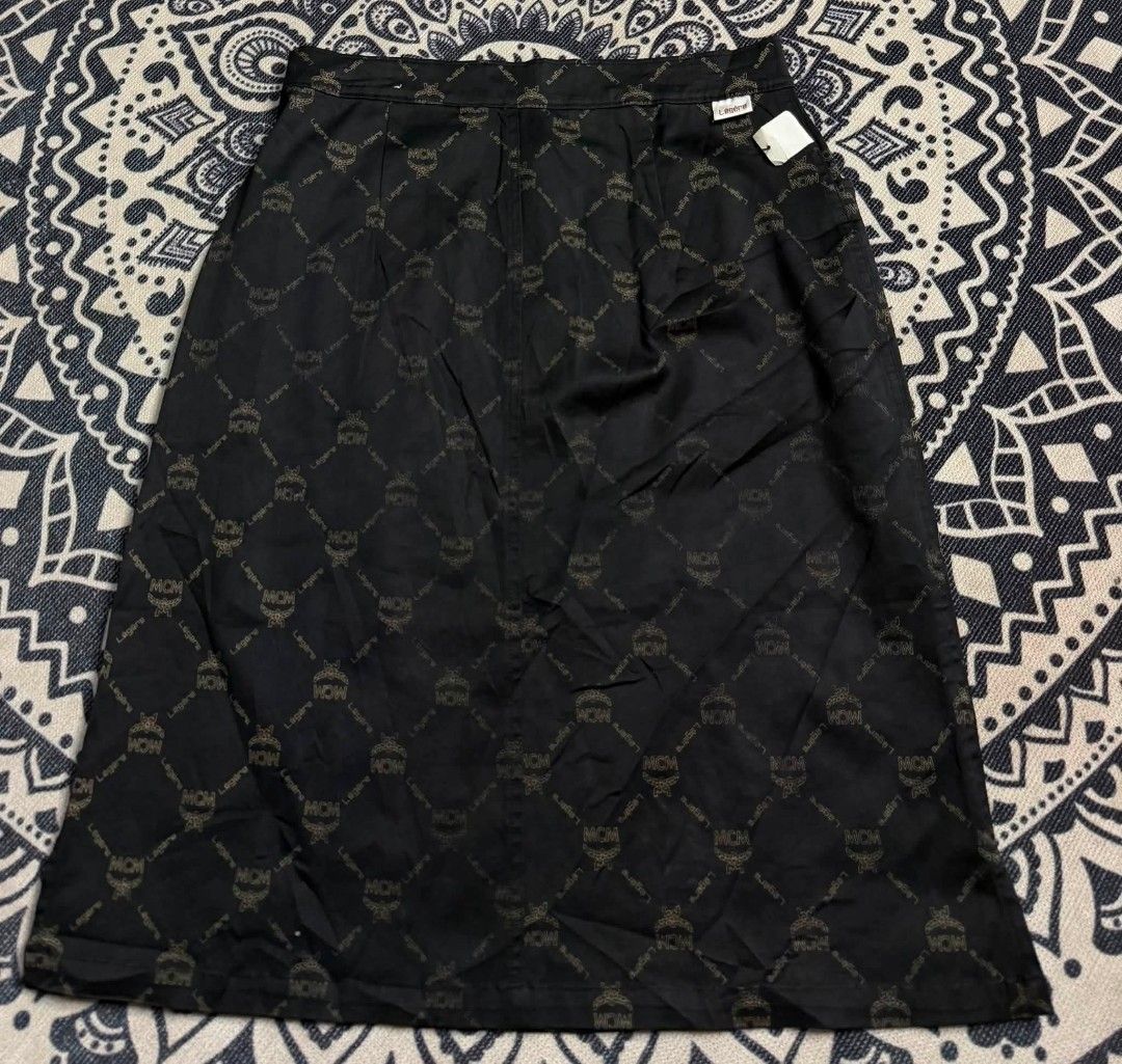 MCM Legere Monogram Midi Skirt (Category: Skirts) located in Andop. Submitted by sionyzoerhoin191326 (Listing ID 1461678928, Image 3). Description: - Black midi skirt - All-over MCM monogram print - Button and zip closure at the front - Functional pockets - Fabric with a slight sheen -29-30 - Versatile for dressing up or down.