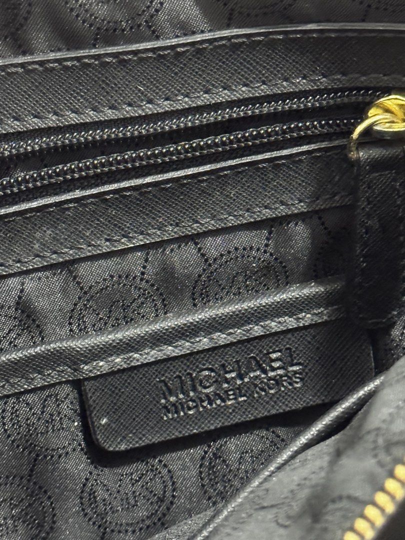 Michael Kors Black Leather Tote Bag (Category: Tote Bags) located in Bauang. Submitted by jeneefromtheblock (Listing ID 1461774505, Image 3). Description: - Original Black Michael Kors tote bag - Genuine leather material - Elegant gold hardware details - Convenient exterior side pockets - Spacious interior with multiple compartments - Signs of wear on bottom corners and some marks on the front - Comes with original dust bag - Ideal everyday bag.